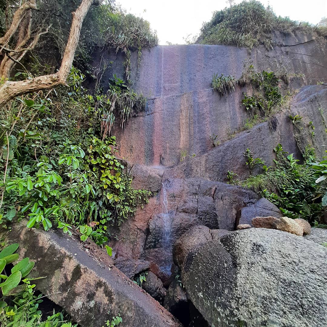 Enorme formação rochosa e cachoeira no canto direito da Praia do Simão