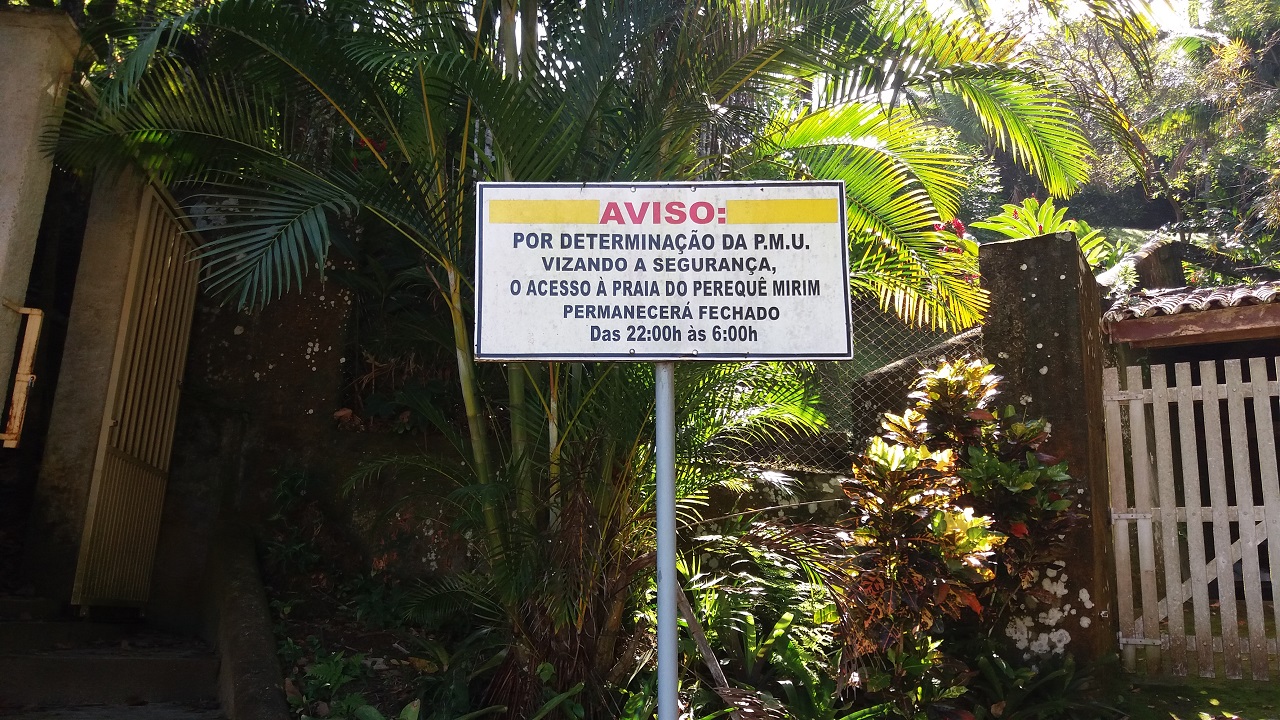 Placa bem ao lado do portão no início da trilha na Praia de Santa Rita